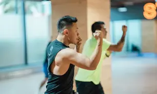 GNMen performing upper-body strikes during a BODYCOMBAT session at GymNation, focused on cardio and strength.